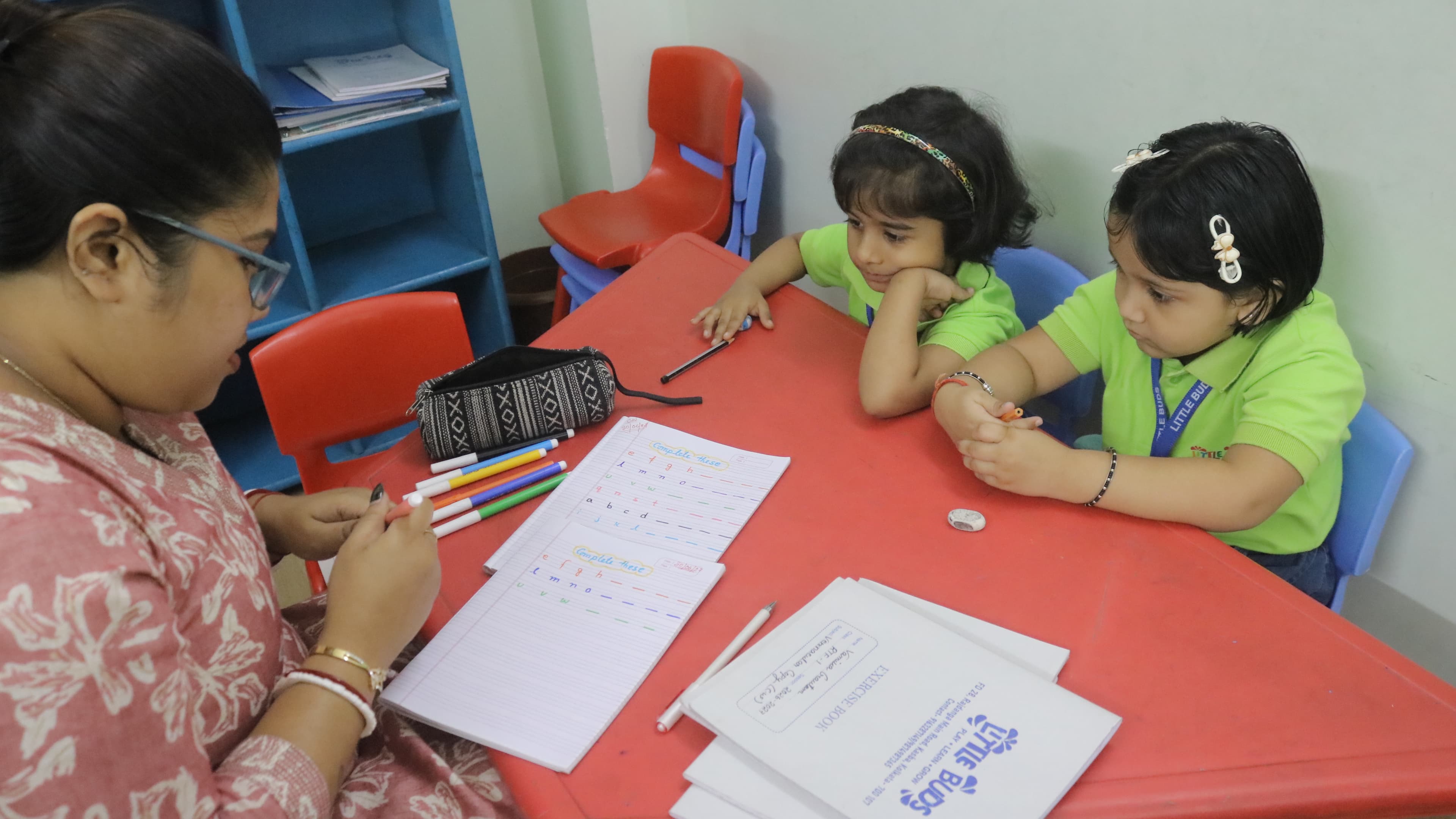 Teacher guiding Little Buds students through a writing activity