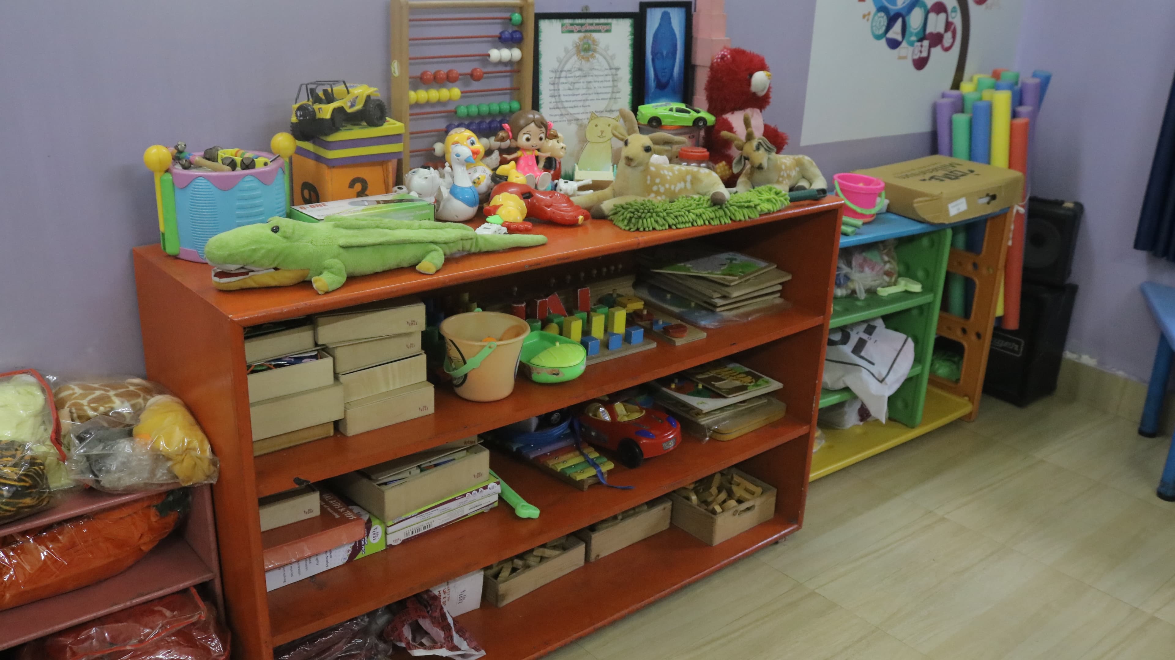 Colourful toys and learning materials on the Little Buds playroom shelves