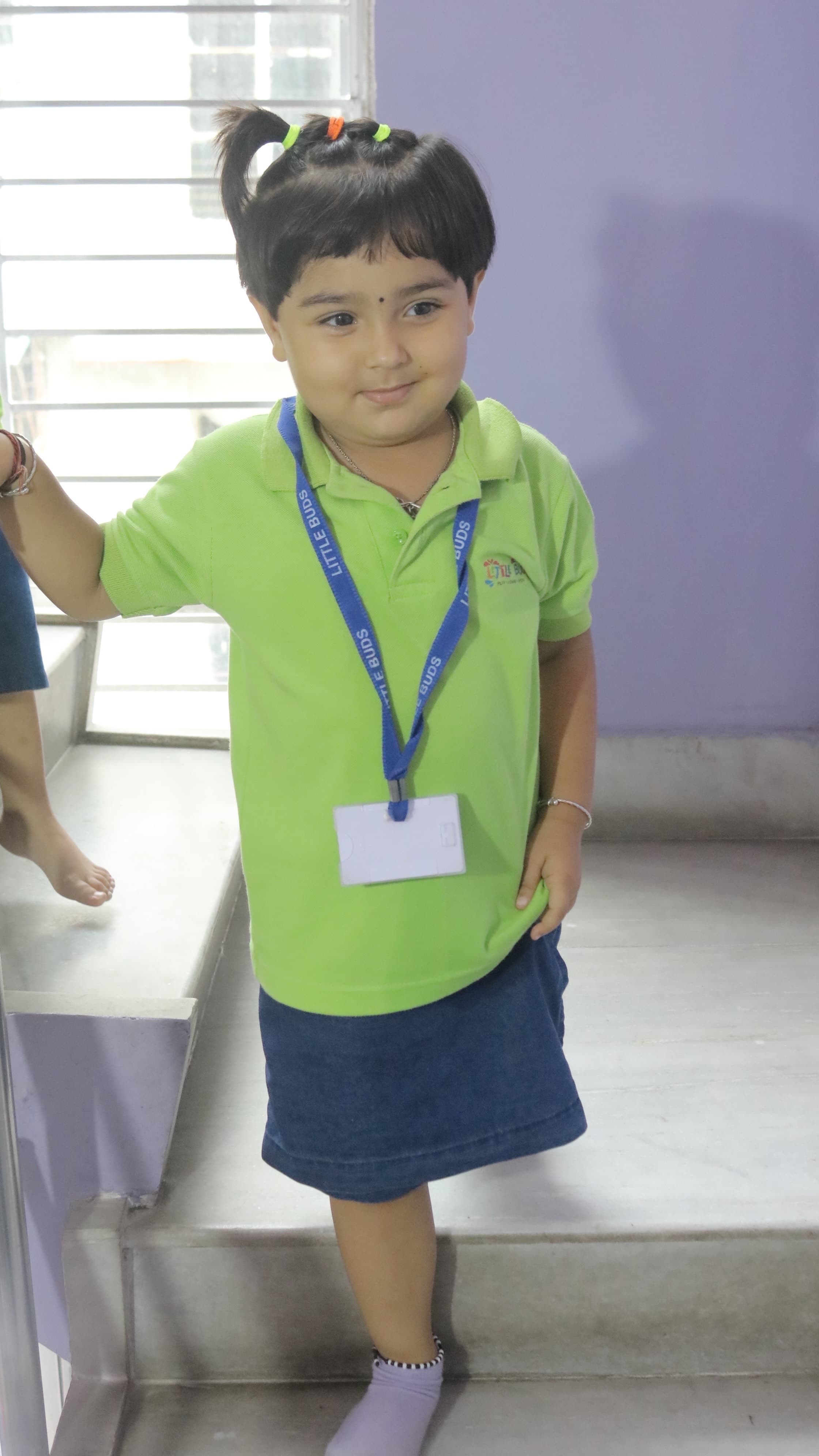 Little Buds student standing on the school stairs