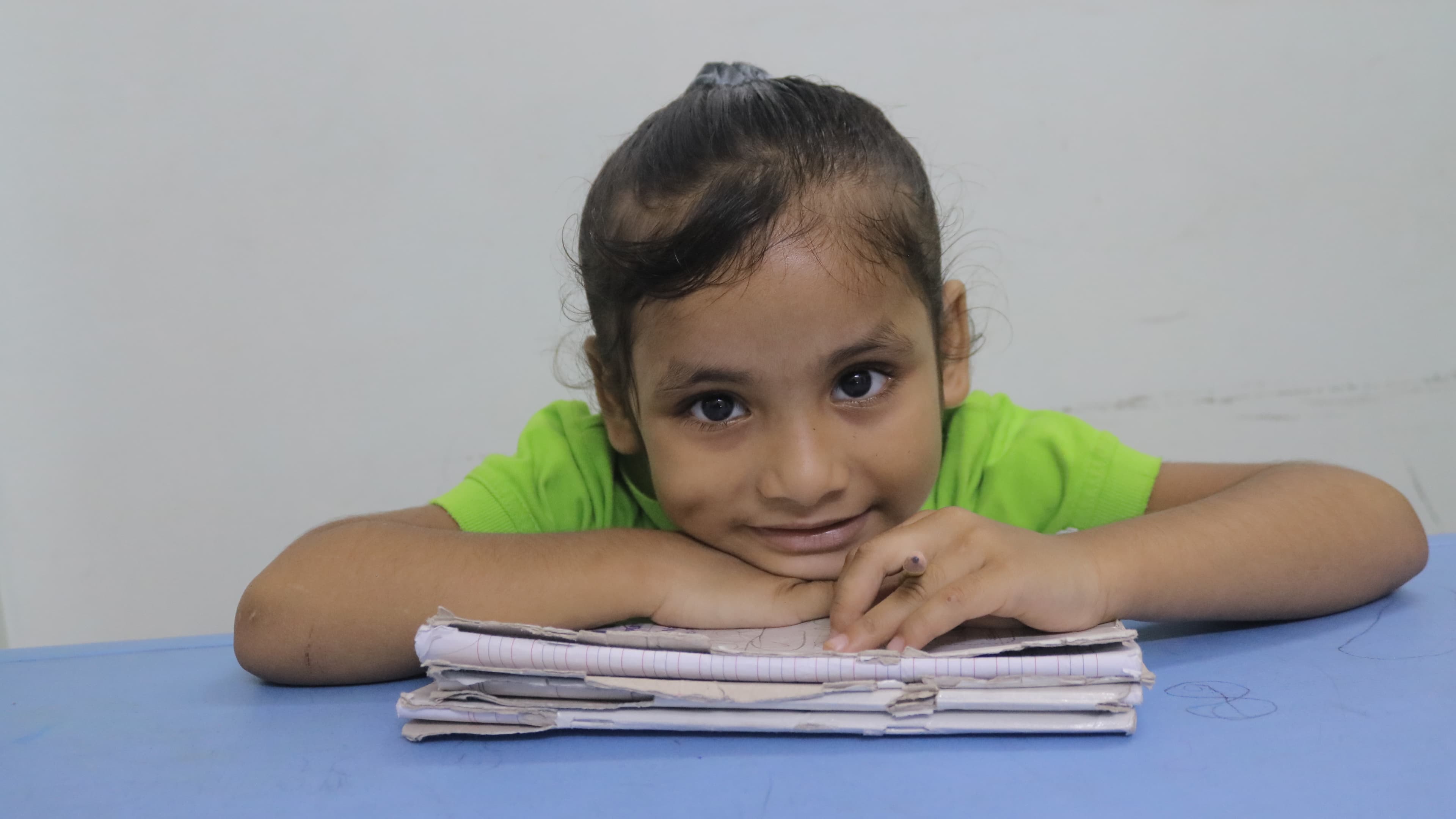 Little Buds student resting at her desk with a gentle smile